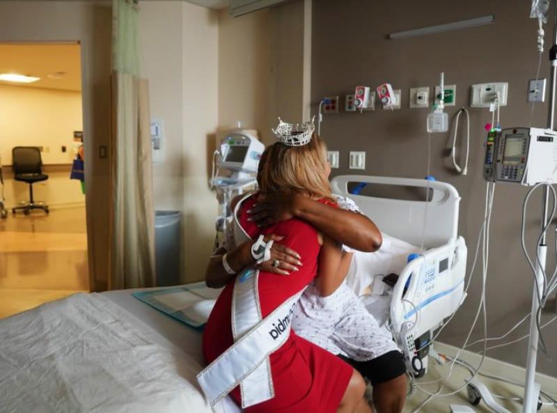 Jude Maboné hugging and giving words of encouragement to a patient in the hospital awaiting major surgery. (Photo courtesy of Jude Maboné)